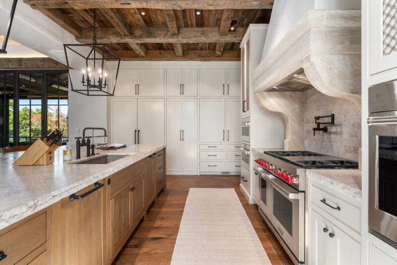 interior view of Ridgeline kitchen with ample storage, overhead lighting, and a long kitchen island with commercial grade ovens