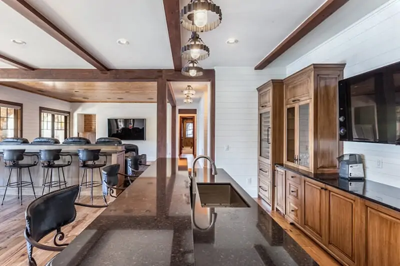 Kitchen Island with Chairs Around it With View of Dining Table and Appliances in Kitchen