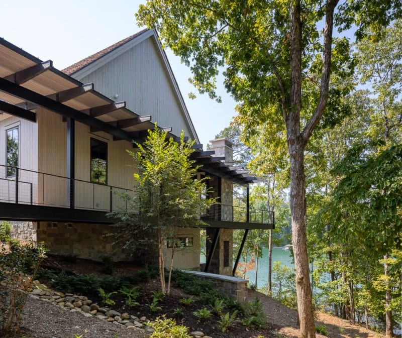 Side view of house with view of lake through trees