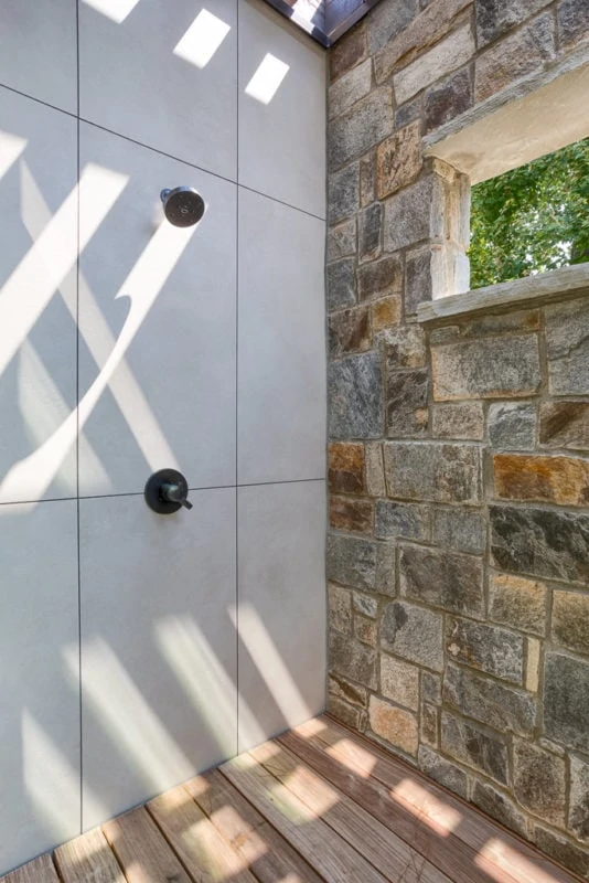 Shower with wood floor and stone wall