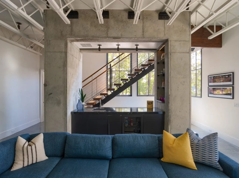 Bar behind blue sofa leading to stairs