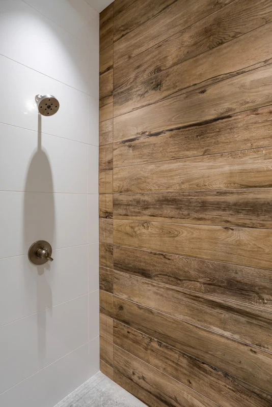 Walk in shower with wood grain accent wall