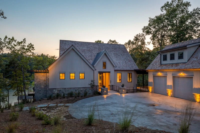 Grey custom home with coach lights and house lights on