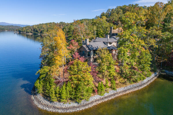 Aerial image of home surrounded by trees and lake
