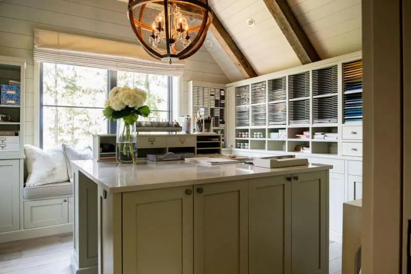 Design Studio interior of a hobby or craft room with storage cabinets, window seating and a overhead light fixture
