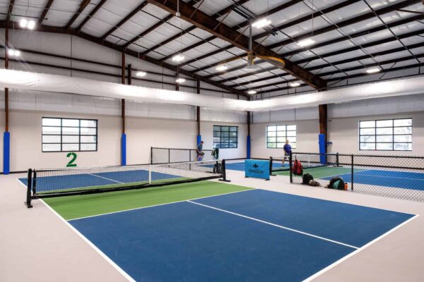 two indoor pickle ball courts with players