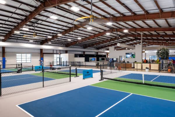 Indoor facility featuring pickle ball courts and golf simulator bay