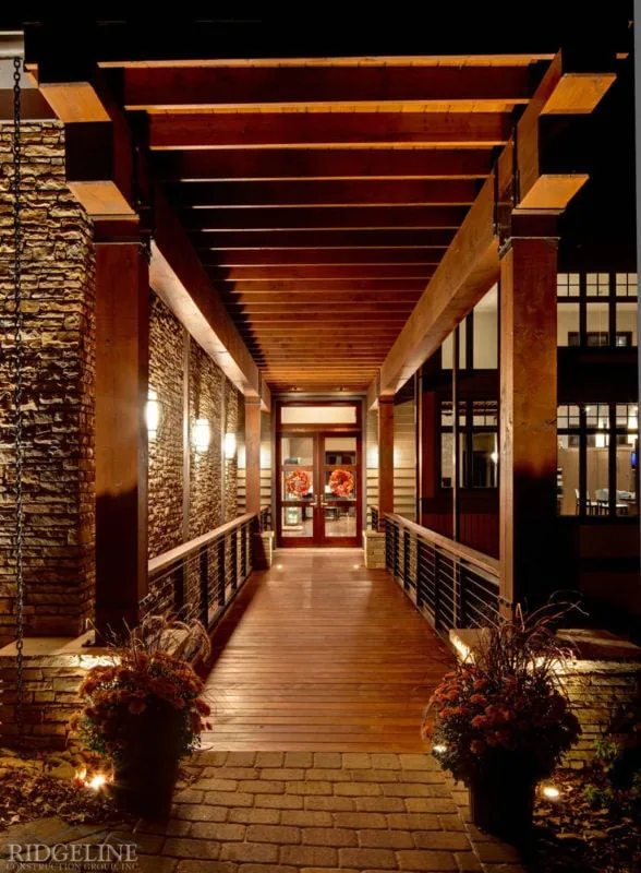 covered wooden walkway leading up to the double glass front doors