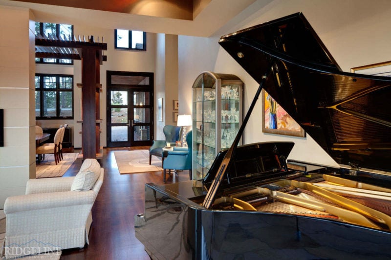 view of foyer showing the back of a grand piano, glass amour and small sitting area