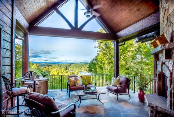 enclosed patio with seating area and fire place with views overlooking top of forest and lakes