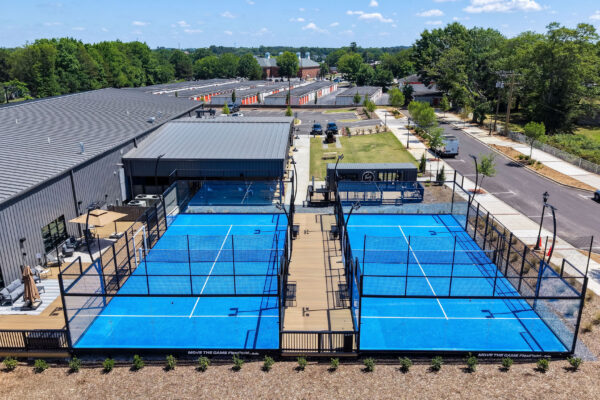 two blue pickleball courts with seating areas