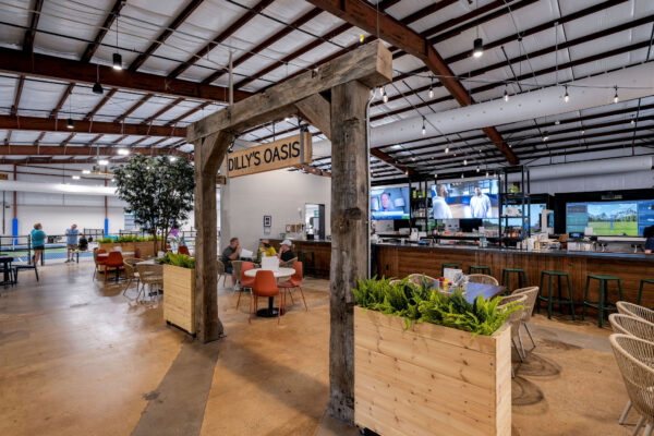 Dilly's Oasis area at pickleyard with seating and golf simulator in background
