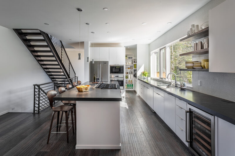 Kitchen Island with Chairs Around it With View of Appliances in Kitchen