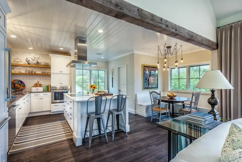 Kitchen Island with Chairs Around it With View of Dining Table and Appliances in Kitchen