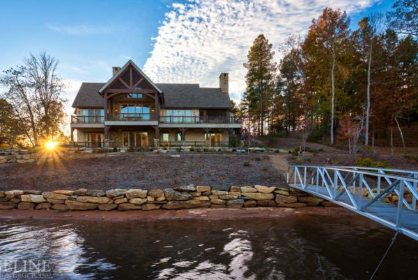 landscape of back of lake house with bridge going out into water