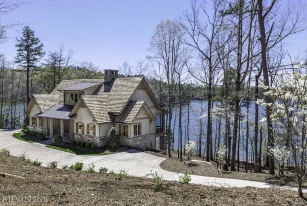 white home with stone accents overlooking lake