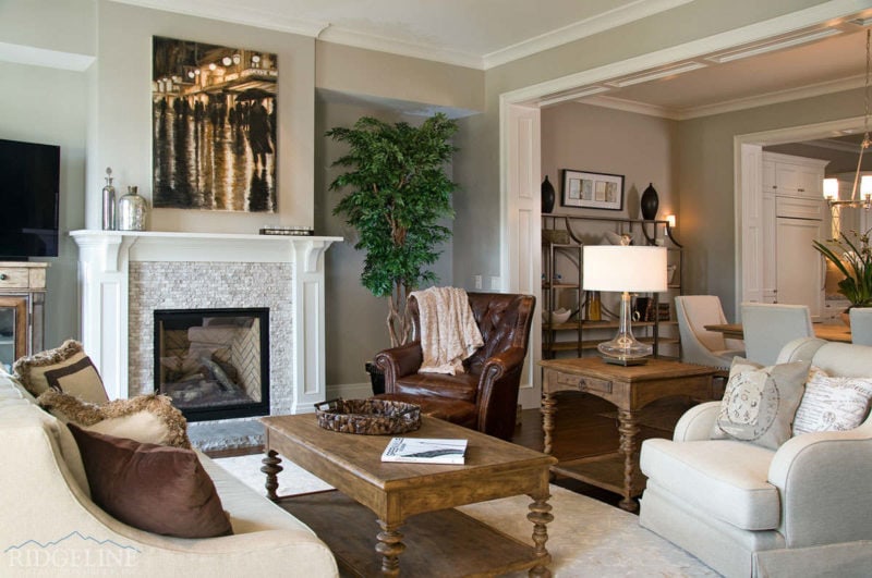 living room with white fireplace and brown furniture