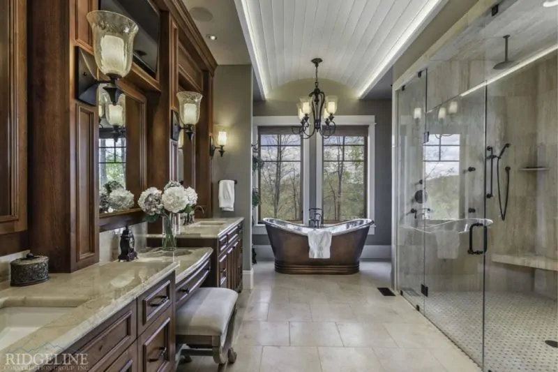 bathroom with brown cabinets and luxury tub overlooking forest