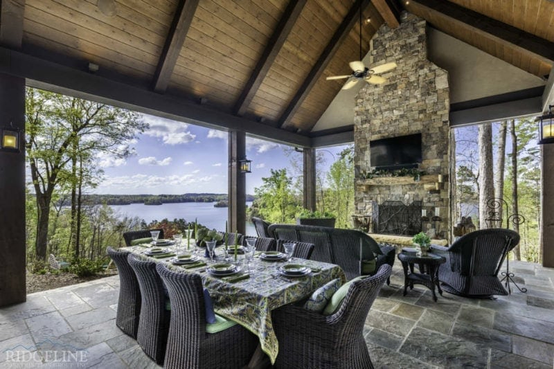 Covered outdoor dining and living area with fireplace and television