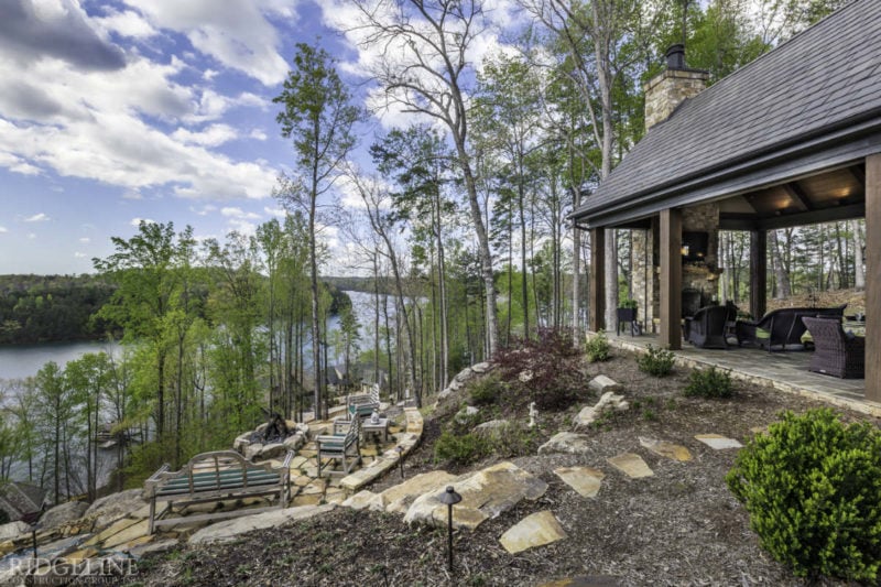 patio of mountain home with steps leading down to lake