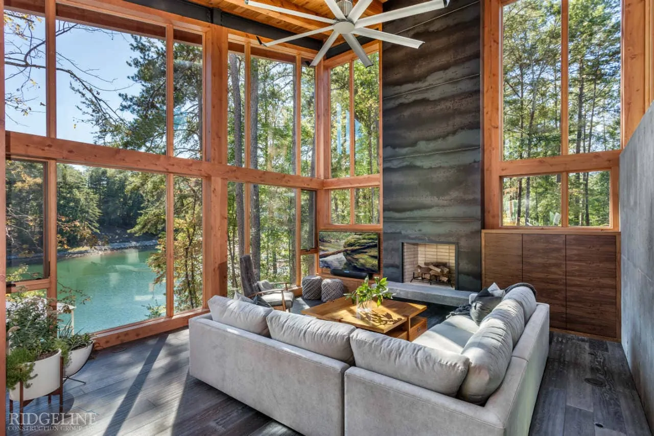 living room with high ceilings, fireplace and open windows overlooking lake