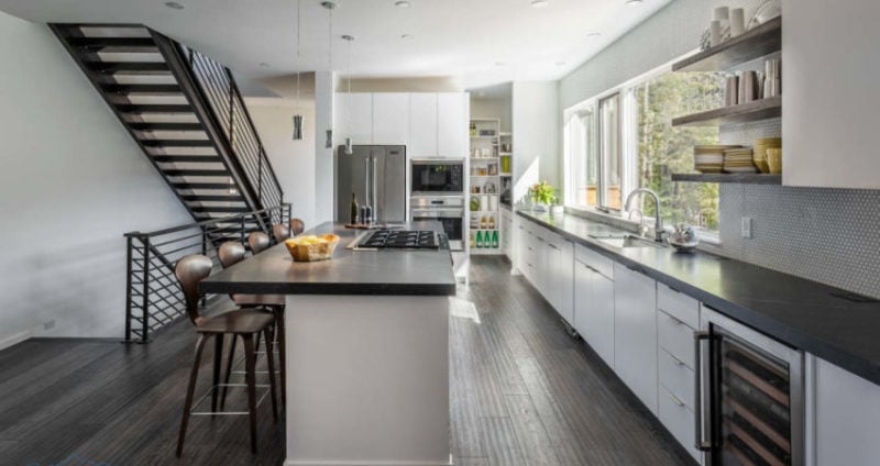 Kitchen with island, dark countertops, and modern bartools