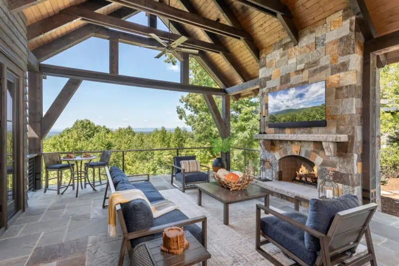 covered outdoor patio with built in fireplace, television, and seating