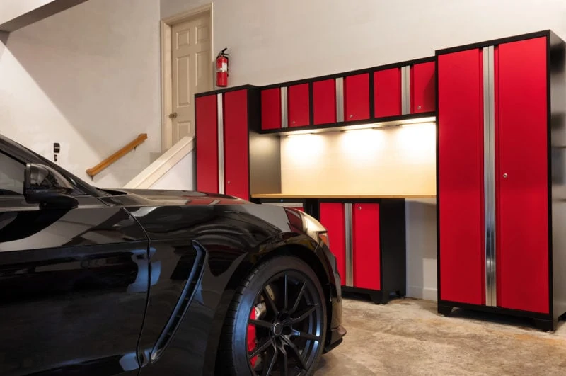 Inside garage with black car and red cabinet and shelves