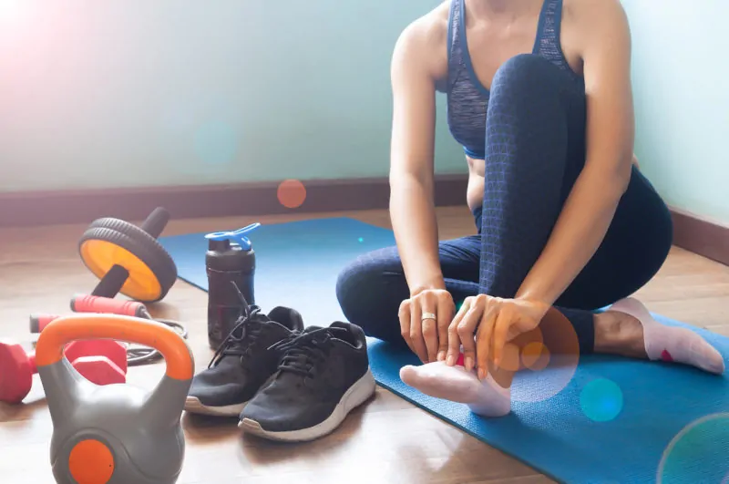 woman with sneakers weights and in workout clothes