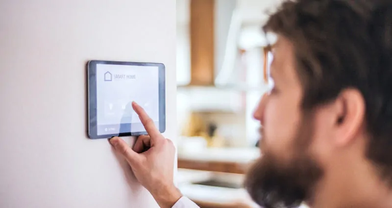 man adjusting temperature with smart tech