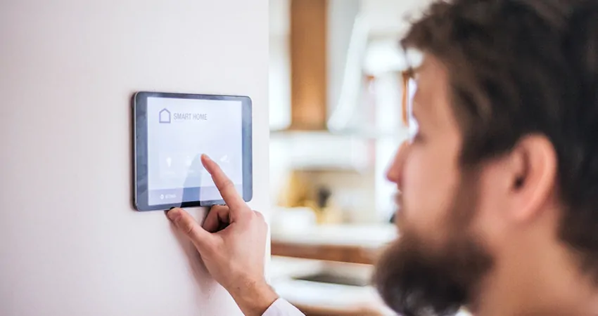 man adjusting temperature with smart tech