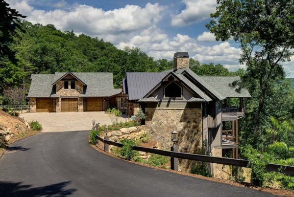 view of long curved driveway leading up to mountain home built down the mountain