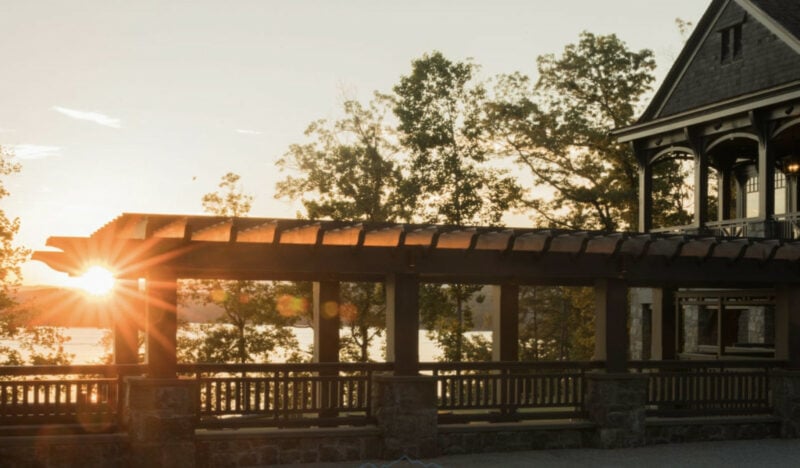 covered walk way over water connected to custom lakefront home