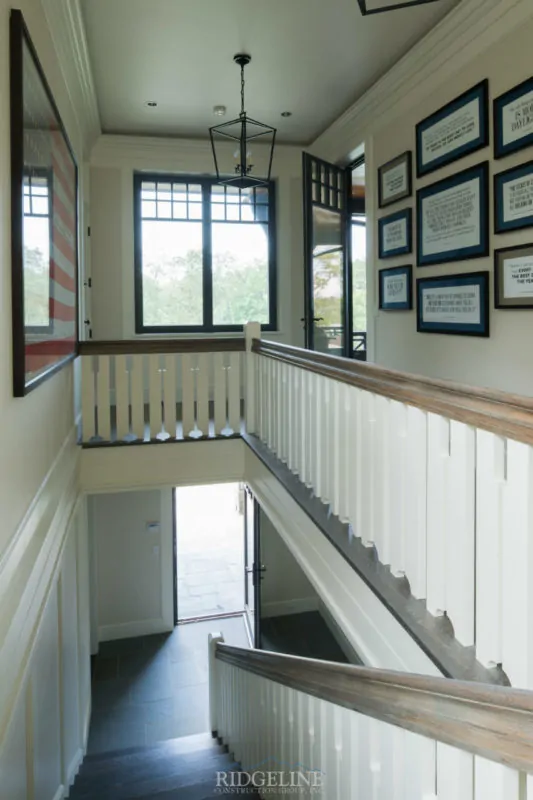 top of staircase with picture frames on right wall