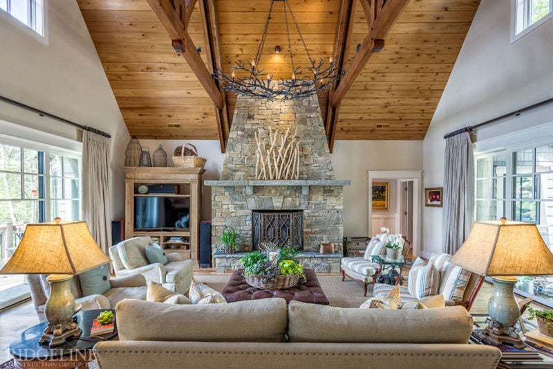 living room with grande stone fireplace and high ceilings