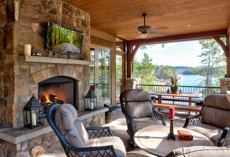 Covered patio with fireplace, tv, and chair