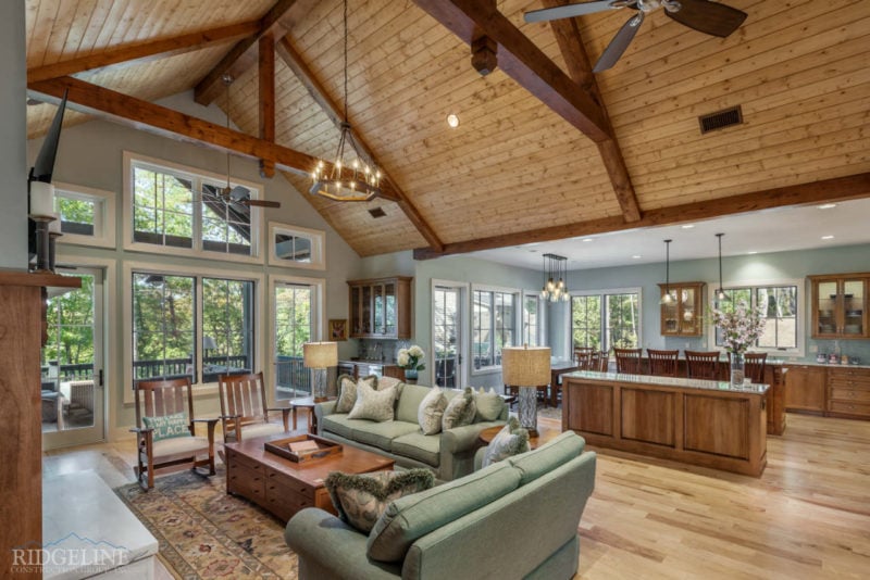 Living room with green couches and exposed beams