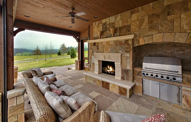 luxurious outdoor kitchen with stone facade overlooking golf course