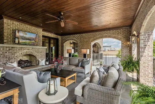 outdoor fireplace with tv above and patio furniture set surrounding